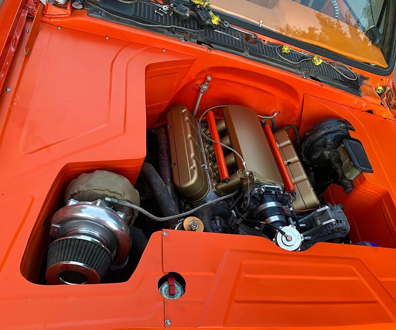 Compartimento de motor terminado en naranja, tapas de punterías doradas y turbo